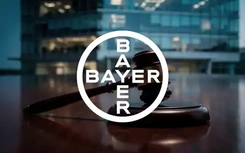 Ein hölzerner Auktionshammer auf einem dunklen Tisch vor einem unscharfen Bürogebäude bei Dämmerung. - Foto: über boerse-global.de