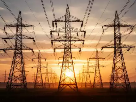 Hochspannungsleitungen und Strommasten in der Abendsonne als Symbol für die steigenden Stromnetzgebühren. - Foto: über boerse-global.de