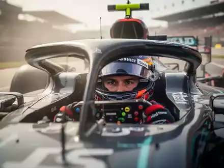 Ein Formel-1-Fahrer im Cockpit während eines Rennens, fokussiert auf mentale Stärke und technische Präzision. - Foto: über boerse-global.de