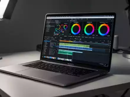 Ein MacBook Pro auf einem modernen Schreibtisch, auf dessen Bildschirm eine professionelle Videoschnitt-Software zu sehen ist. - Foto: über boerse-global.de