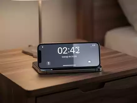 Ein iPhone im StandBy-Modus zeigt eine digitale Uhr auf einem Nachttisch bei sanfter Beleuchtung. - Foto: über boerse-global.de