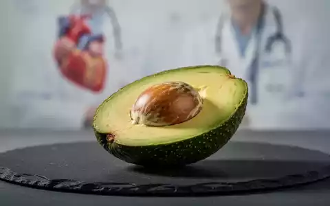 Eine halbierte frische Avocado auf einer dunklen Schieferplatte vor einem verschwommenen medizinischen Hintergrund. - Foto: über boerse-global.de