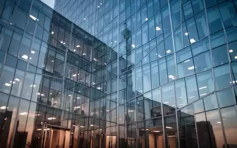 Moderne Glasfassade eines Bürogebäudes mit Spiegelungen, symbolisch für den Finanzsektor und Unternehmensübernahmen. - Foto: über boerse-global.de