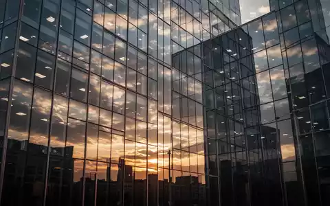 Moderne Glasfassade eines Bürogebäudes bei Sonnenuntergang als Symbol für Immobilienwirtschaft und Finanzlage. - Foto: über boerse-global.de