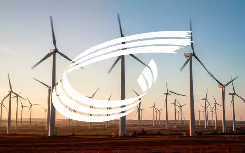 Moderne Windkraftanlagen in einer weitläufigen Landschaft bei Sonnenuntergang als Symbol für Erneuerbare Energien. - Foto: über boerse-global.de
