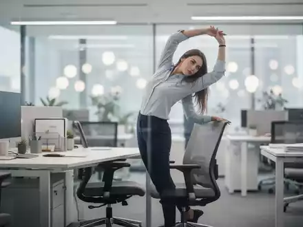 Eine Frau macht eine kurze Bewegungspause an ihrem modernen Büroarbeitsplatz, um aktiv zu bleiben. - Foto: über boerse-global.de