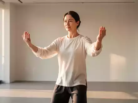 Eine Person praktiziert Qigong-Übungen in einem hellen, minimalistischen Raum mit Fokus auf achtsame Bewegungen. - Foto: über boerse-global.de