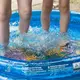 Kinder stehen in einem Planschbecken. - Bild: Sebastian Kahnert/dpa