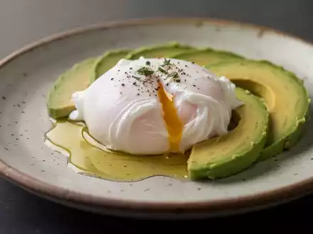 Ein perfekt pochiertes Ei auf einem Teller, serviert mit Avocado und Olivenöl in einer hochwertigen Food-Fotografie. - Foto: über boerse-global.de