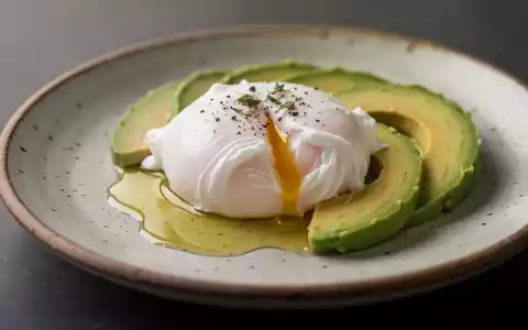 Ein perfekt pochiertes Ei auf einem Teller, serviert mit Avocado und Olivenöl in einer hochwertigen Food-Fotografie. - Foto: über boerse-global.de