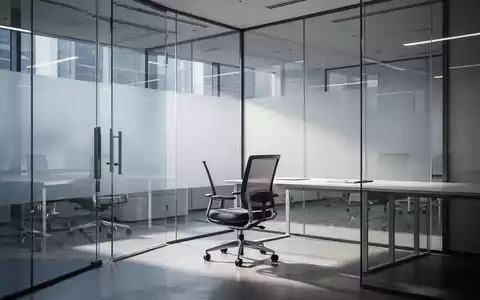 Ein moderner, leerer Büroarbeitsplatz mit einem ergonomischen Stuhl vor einer Glasfront in einem professionellen Umfeld. - Foto: über boerse-global.de