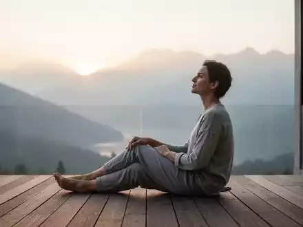 Eine entspannte Person blickt morgens in eine ruhige Berglandschaft, um das Konzept der aktiven Erholung zu symbolisieren. - Foto: über boerse-global.de