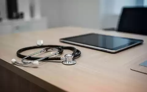 Stethoskop und digitales Tablet auf einem Schreibtisch in einer modernen Arztpraxis als Symbol für die Krankschreibung. - Foto: über boerse-global.de