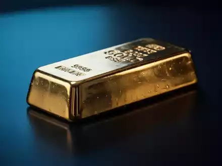 Ein glänzender Goldbarren auf einer dunklen, reflektierenden Oberfläche bei stimmungsvoller Beleuchtung. - Foto: über boerse-global.de