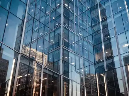 Moderne Glasfassade eines Bürogebäudes in einem Finanzviertel bei klarem Himmel. - Foto: über boerse-global.de