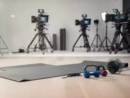 Modernes Fernsehstudio für Fitness- und Gesundheitssendungen mit Sportausrüstung vor einem hellen, professionellen Hintergrund. - Foto: über boerse-global.de