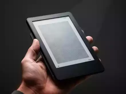 Schlankes, handliches E-Reader-Gerät in einer Hand, mit klarem E-Ink-Display auf neutralem Hintergrund. - Foto: über boerse-global.de