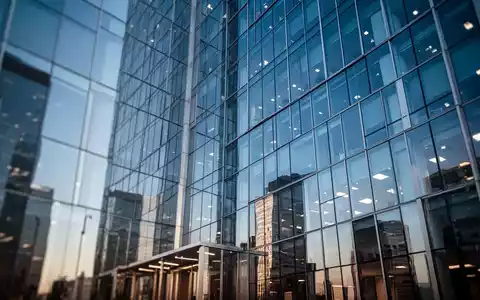 Moderne Glasfassade eines Bürogebäudes bei klarem Himmel als Symbol für wirtschaftlichen Erfolg. - Foto: über boerse-global.de