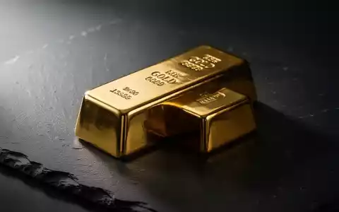 Ein einzelner Goldbarren auf einer dunklen Schieferplatte mit dramatischer Beleuchtung. - Foto: über boerse-global.de