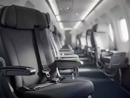 Ein leerer Sitz in einer modernen Verkehrsflugzeugkabine mit angeschnalltem Sicherheitsgurt. - Foto: über boerse-global.de