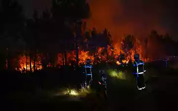 Die Löscheinsätze der Feuerwehr halten über Nacht an. - Foto: Emma Da Silva/AP/dpa