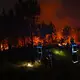 Die Löscheinsätze der Feuerwehr halten über Nacht an. - Bild: Emma Da Silva/AP/dpa