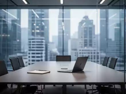 Modernes, minimalistisches Büro mit Konferenztisch und Laptop vor einer Glasfassade. - Foto: über boerse-global.de