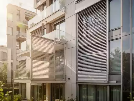 Moderne Gebäudefassade mit außenliegendem Sonnenschutz an einem sonnigen Sommertag. - Foto: über boerse-global.de