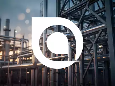 Moderne industrielle Anlage mit silbernen Rohrleitungen und geometrischen Stahlstrukturen in atmosphärischem Licht. - Foto: über boerse-global.de
