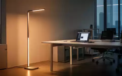 Moderne, ergonomische Stehleuchte in einem professionellen Büroarbeitsplatz mit Laptop und sauberem Schreibtisch-Design. - Foto: über boerse-global.de
