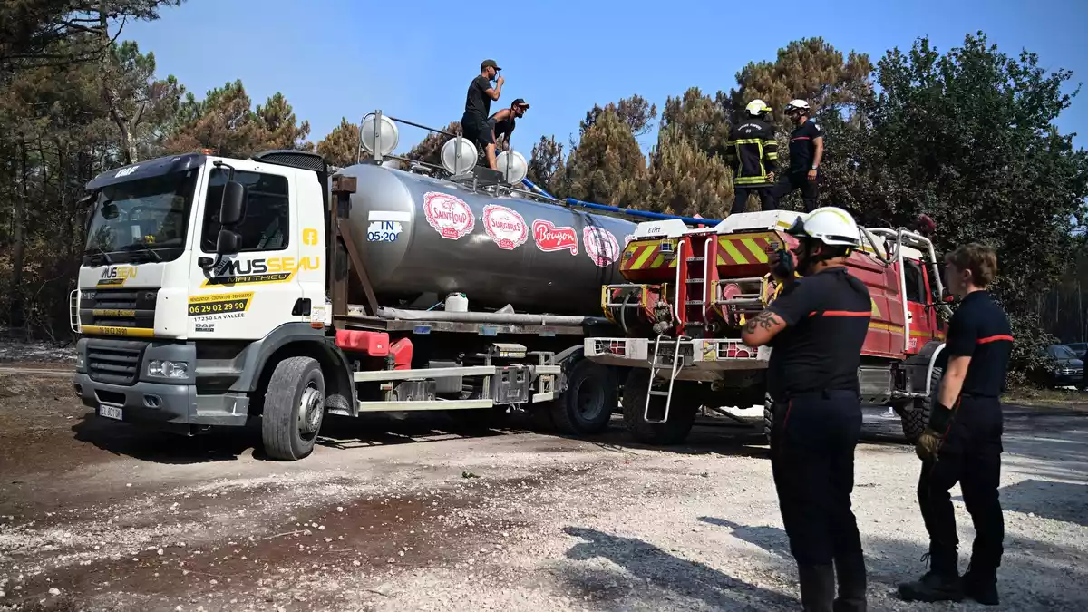 Viele Freiwillige unterstützen den Einsatz der Feuerwehr, unter anderem, in dem sie mit privaten Tankwagen Wasser für die Feuerwehr herbeischaffen. - Bild: Emma Da Silva/AP/dpa