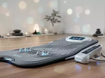 Moderne Vibrationsmatte und Massagegerät für die Gelenktherapie in einer hellen, minimalistischen Wellness-Umgebung. - Foto: über boerse-global.de