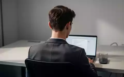 Junge Person bei der Arbeit am Laptop in einer modernen Büroumgebung mit Fokus auf die Körperhaltung. - Foto: über boerse-global.de