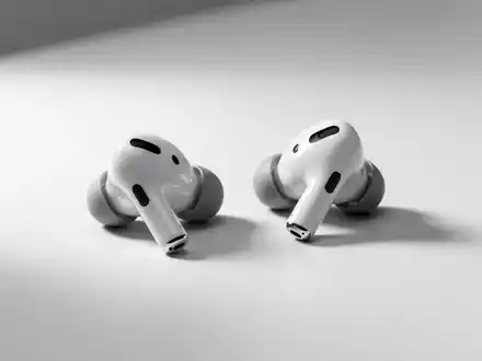 Apple AirPods Pro 3 Ohrhörer auf minimalistischer Oberfläche unter weichem Studio-Licht. - Foto: über boerse-global.de