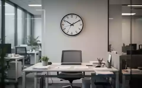 Ein leerer Arbeitsplatz mit einer Wanduhr im Hintergrund, die das Thema Arbeitszeit und Work-Life-Balance symbolisiert. - Foto: über boerse-global.de
