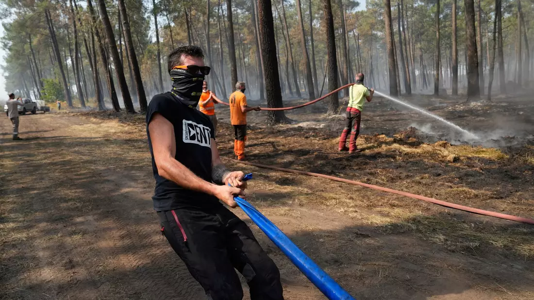 Bei ihren Löscharbeiten wird die Feuerwehr in Frankreich von Anwohnern, Landwirten und weiteren Freiwilligen unterstützt. - Bild: Baz Ratner/AP/dpa