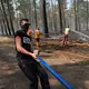 Bei ihren Löscharbeiten wird die Feuerwehr in Frankreich von Anwohnern, Landwirten und weiteren Freiwilligen unterstützt. - Bild: Baz Ratner/AP/dpa
