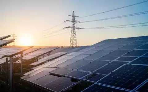 Moderne Solarpark-Anlage mit Strommasten bei Sonnenaufgang als Symbol für die Energiewende und Netzstabilität. - Foto: über boerse-global.de