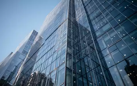 Moderne Glasfassade eines Hochhauses bei klarem Himmel als Symbol für wirtschaftliches Wachstum. - Foto: über boerse-global.de