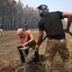 Die Einsatzkräfte und auch freiwillige bekämpfen die Flammen. - Bild: Romain Perrocheau/AFP/dpa