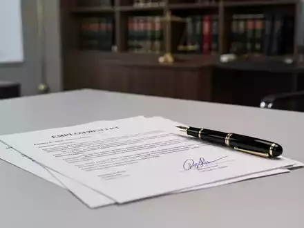 Ein unterzeichneter Arbeitsvertrag liegt auf einem Schreibtisch mit einem Füllfederhalter. - Foto: über boerse-global.de