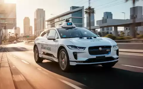 Ein Waymo-Robotaxi fährt bei hellem Tageslicht auf einer Autobahn in Phoenix. - Foto: über boerse-global.de