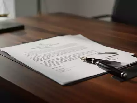 Ein minimalistischer Schreibtisch mit einem juristischen Dokument und einem Füllfederhalter als Symbol für Arbeitsrecht. - Foto: über boerse-global.de