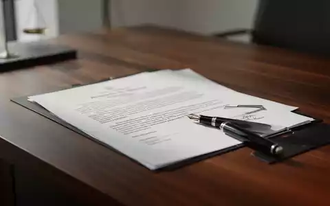 Ein minimalistischer Schreibtisch mit einem juristischen Dokument und einem Füllfederhalter als Symbol für Arbeitsrecht. - Foto: über boerse-global.de