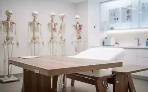 Moderne Praxisräume für Osteopathie mit einer Behandlungsliege und medizinischen Modellen im Hintergrund. - Foto: über boerse-global.de