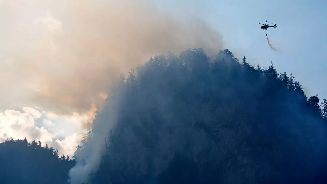 Die Feuerwehr versucht den Brand auch mit Löschhubschraubern zu bekämpfen. - Bild: Uwe Lein/dpa