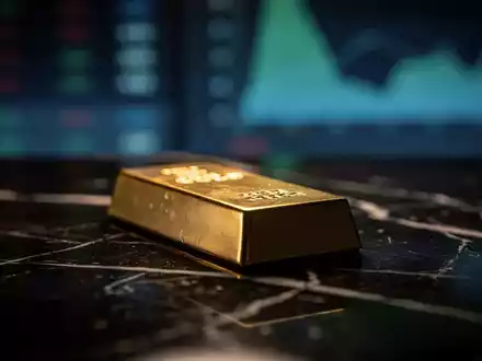Ein glänzender Goldbarren auf einer dunklen Marmoroberfläche bei stimmungsvoller Beleuchtung. - Foto: über boerse-global.de