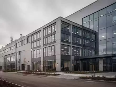 Modernes Industriegebäude eines Produktionsstandorts an einem bewölkten Tag. - Foto: über boerse-global.de