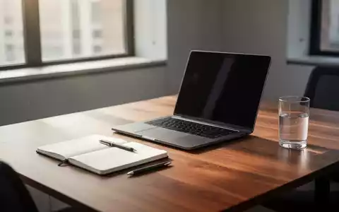 Ein aufgeräumter, minimalistischer Schreibtisch mit Laptop und Notizbuch in hellem, natürlichem Licht. - Foto: über boerse-global.de