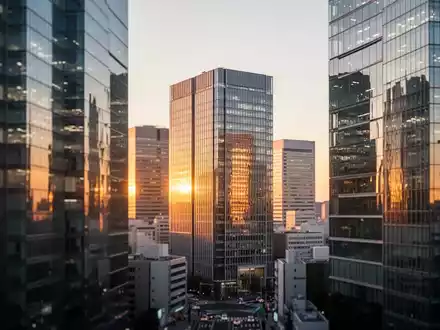 Moderne Skyline eines japanischen Finanzviertels bei Dämmerung mit spiegelnden Bürogebäuden. - Foto: über boerse-global.de